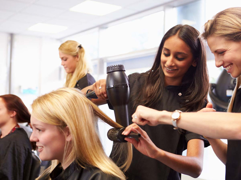 Lehrerin hilft Schülern bei der Ausbildung zum Friseur