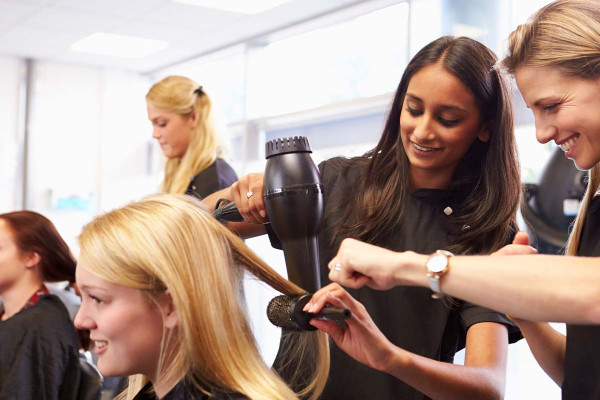 Lehrerin hilft Schülern bei der Ausbildung zum Friseur