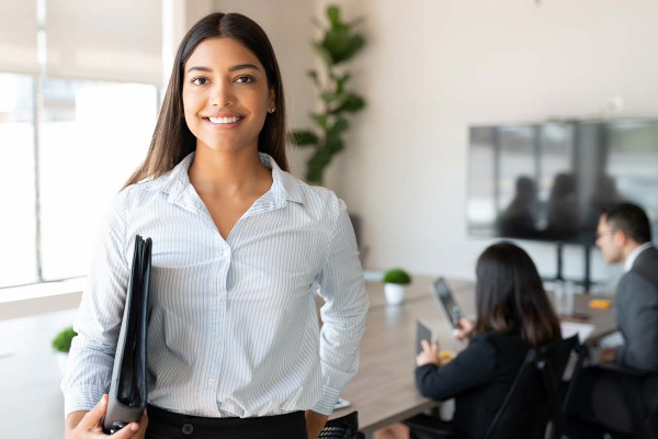 Führungskraft werden ohne Erfahrung: Young Professional in einem Geschäftstermin - lächelnd in die Kamera