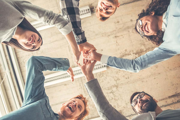 Ein motivierendes Bild, das eine Gruppe von Menschen zeigt, die sich gegenseitig abklatschen. Die Personen stehen in einem Kreis, lächeln und strahlen Freude aus. Diese Szene symbolisiert Teamarbeit, gemeinschaftliche Zielerreichung und die positive Energie, die entsteht, wenn man zusammen ins Handeln kommt. Ideal zur Veranschaulichung von Umsetzungskompetenz und kollektiven Erfolgen.