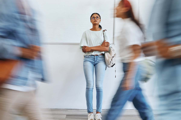 Junge Frau steht nachdenklich allein inmitten vorbeigehender Menschen – Sinnbild für das Gefühl nach einer ungerechten Prüfungsnote und der Suche nach einer Prüfungsanfechtung