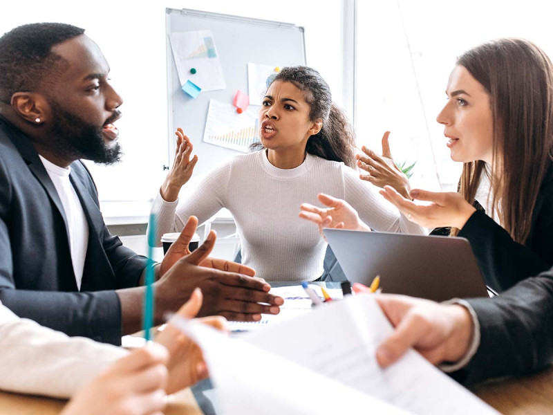 Schlechte Stimmung im Team: drei Kollegen die sich untereinander während der Arbeit streiten