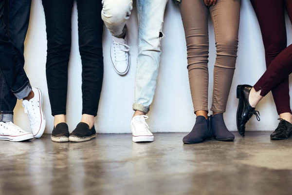 Unterschiedliche Schuhe junger Menschen – symbolisch für die Wahl der passenden Schuhe fürs Vorstellungsgespräch