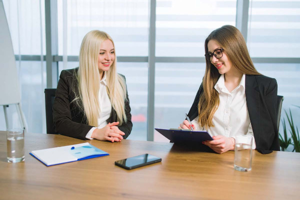 Zwei Frauen in Business-Outfits beim Üben eines Vorstellungsgesprächs – professionelle Vorbereitung auf das Bewerbungsgespräch