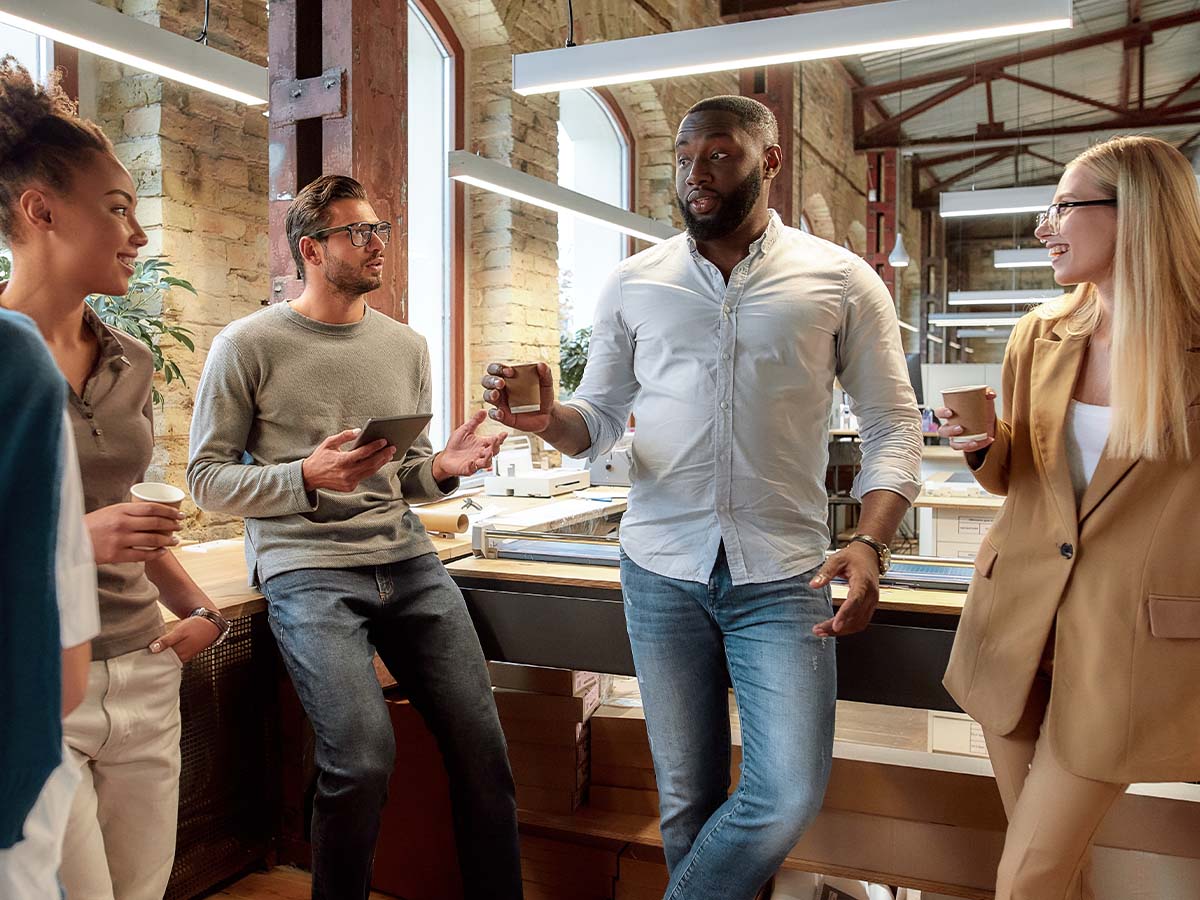 Sich persönlich bei neuen Kollegen während einer Kaffeepause vorstellen und Gespräche im neuen Team führen